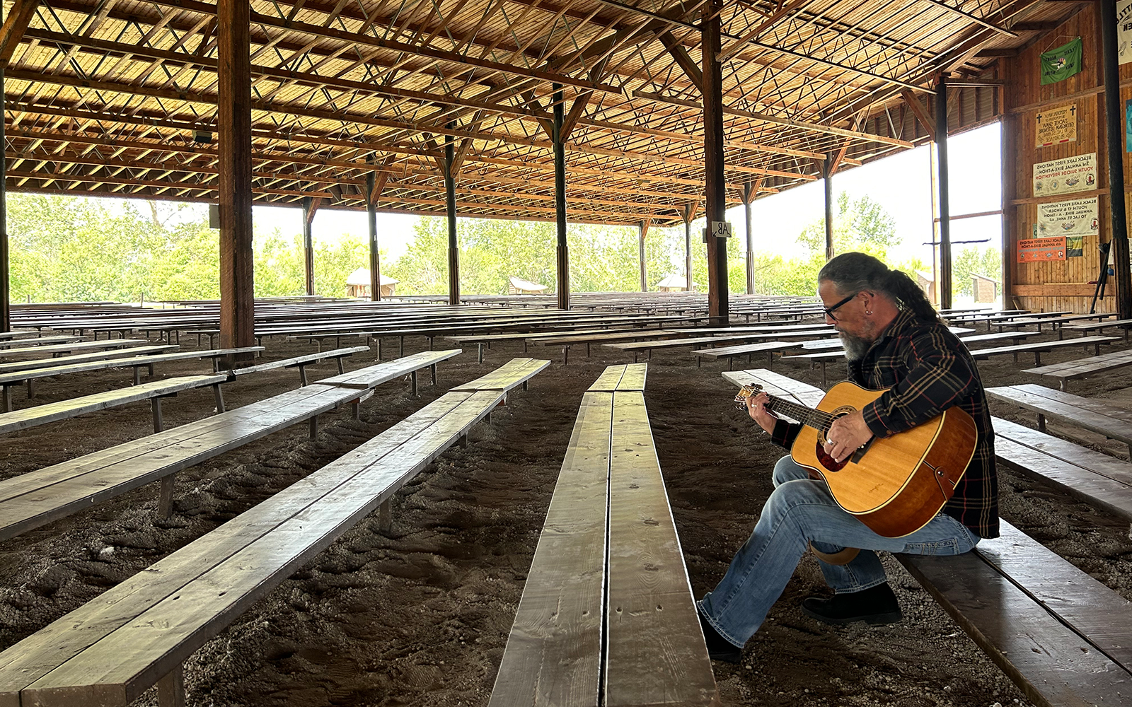 Craig Ginn playing guitar on a bench
